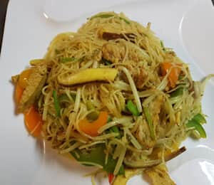 06. Singapore Mai Fun $18.00 Sauteed vermicelli with bell peppers, onions, bean sprouts, and veggie fish cakes in curry sauce