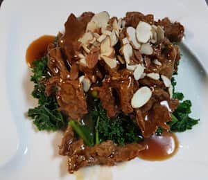 D08. Sweet Citrus Vegan Chicken $19.00 Marinated, thinly sliced soy protein in a sweet and tangy citrus sauce on a bed of kale, topped with almonds