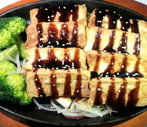 D02. Tofu Teriyaki $17.00 Brown tofu strips in teriyaki sauce on a bed of bean sprouts, broccoli, and onions